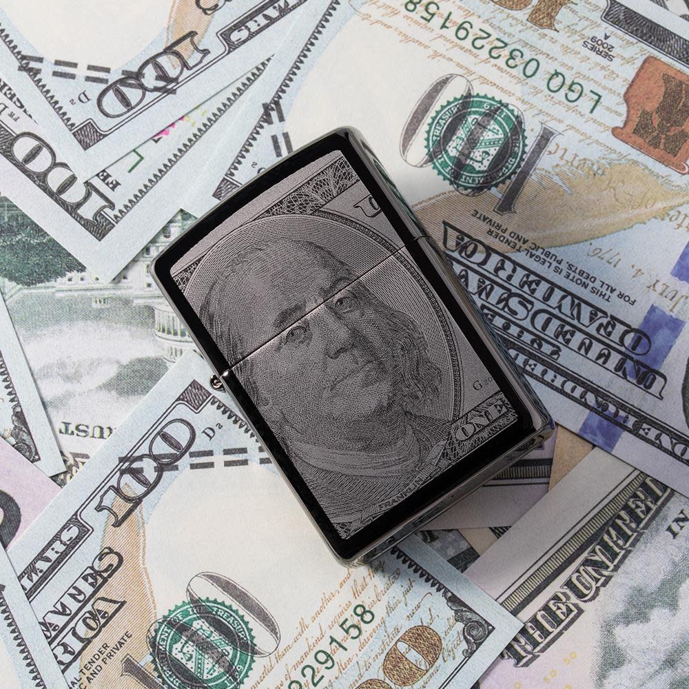 Front view of the Currency Design Lighter laying on a pile of money